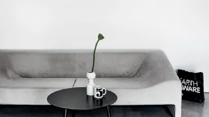 Tavolino rotondo con gambe in legno tinto e top in laminato nero disponibile in due altezze BCN Table di Kristalia